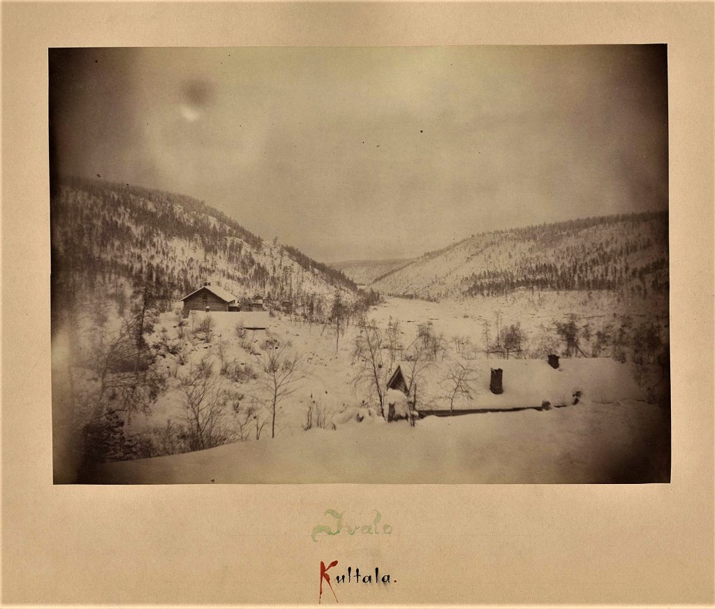 Harvinainen kuva Ivalojoen Kultalasta vv. 1882-1883, jolloin Polaarinen retkikunta tutki siellä revontulia. Etualalla oikealla poliisien väentupa, leipomo, Kultalan päärakennus ja takana näkyvät aitta, kapakka ja rannemmalla kruunuvouti Plantingin mökki.